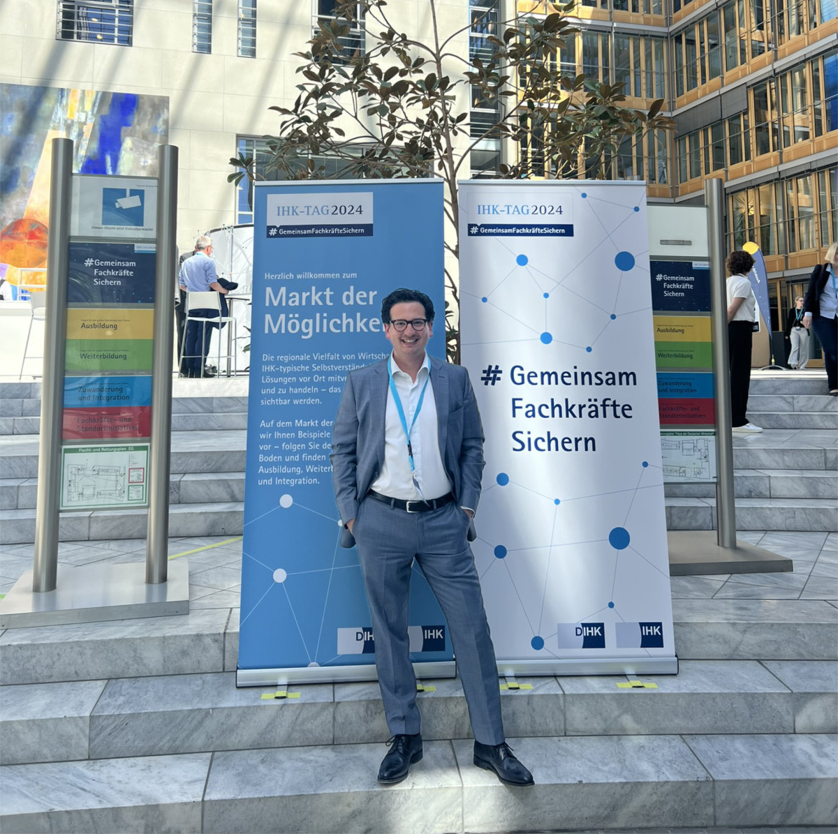 Bastian Mahmoodi beim IHK-Tag 2024 in Berlin vor Bannern mit dem Motto „Gemeinsam Fachkräfte sichern“.