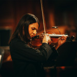 Eine Violinistin spielt konzentriert während eines Konzerts.