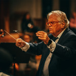 Ein Dirigent leitet ein Orchester während eines Konzerts.