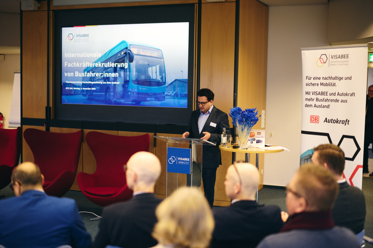 Bastian Mahmoodi hält eine Präsentation zum Thema internationale Fachkräfterekrutierung von Busfahrerinnen und Busfahrern.